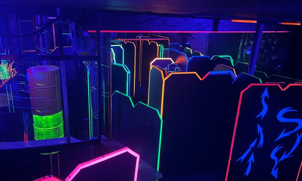 Tamsi lazerių arena su fluorescenciniais labirintais komandiniam žaidimui